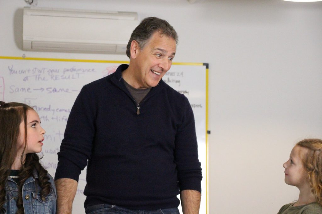 Man smiling and talking to two girls.