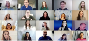 Video conference call with multiple smiling participants.